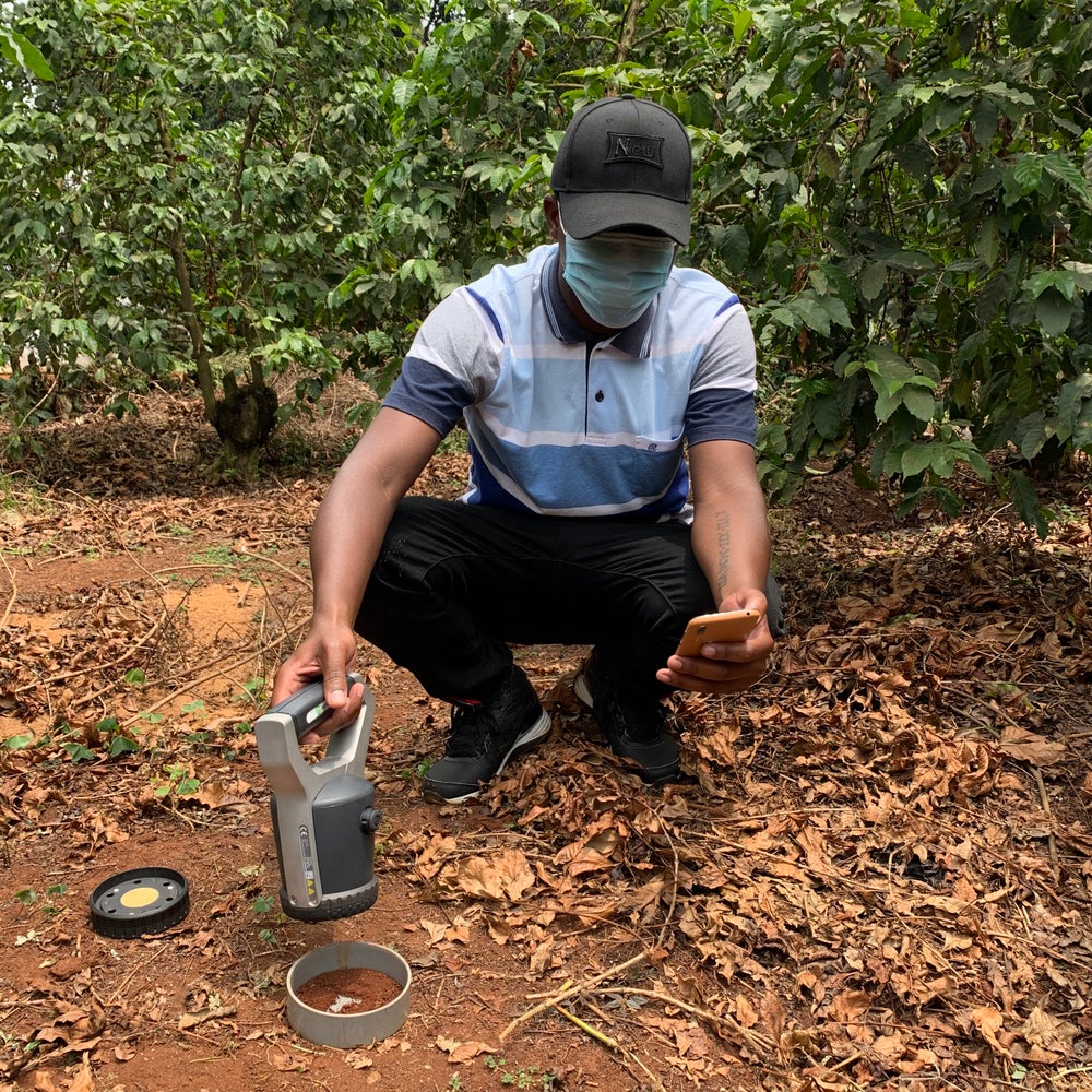 Black person testing soil in a field